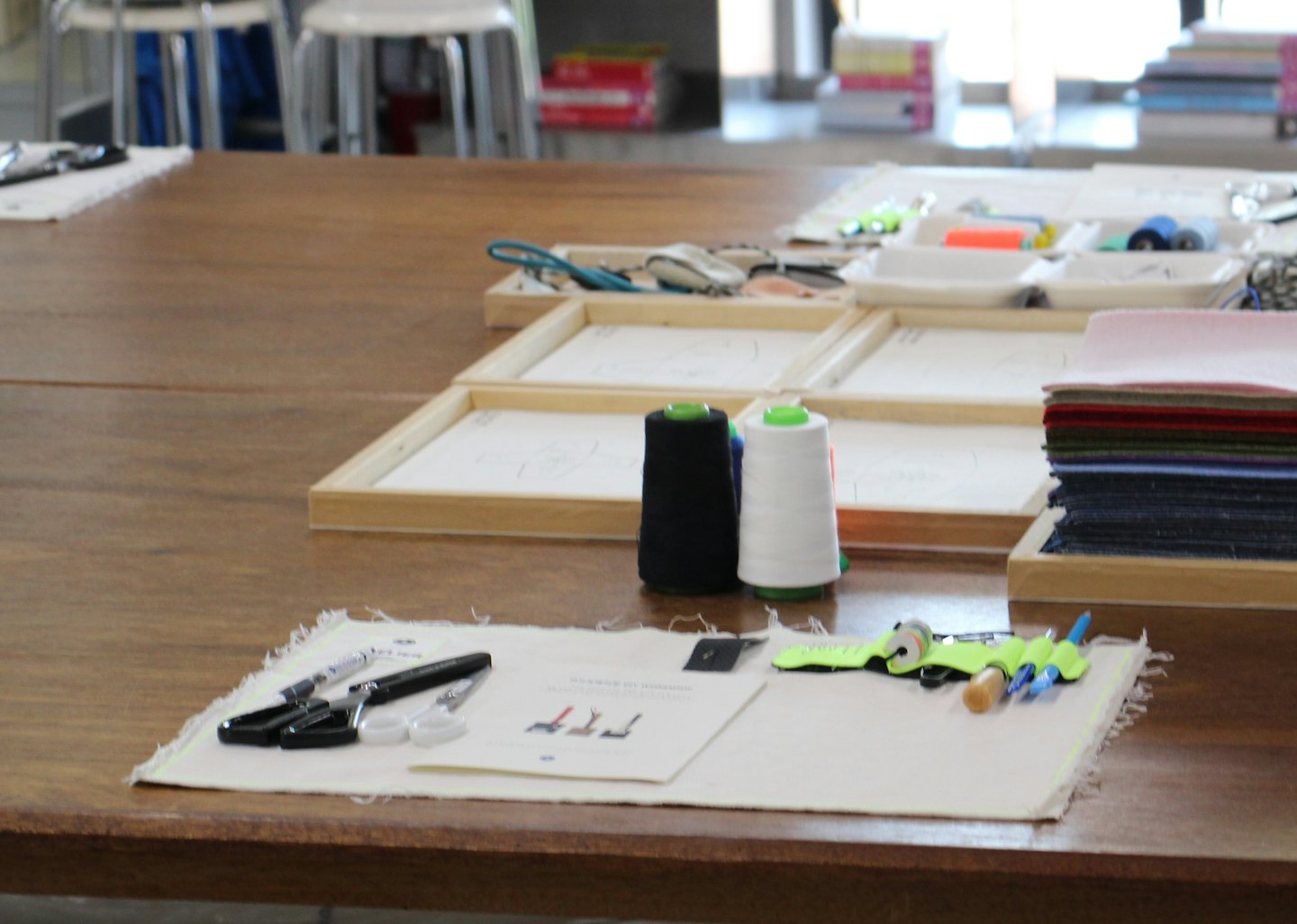 Materiales de artesanía y costura dispuestos sobre una mesa de taller de madera.